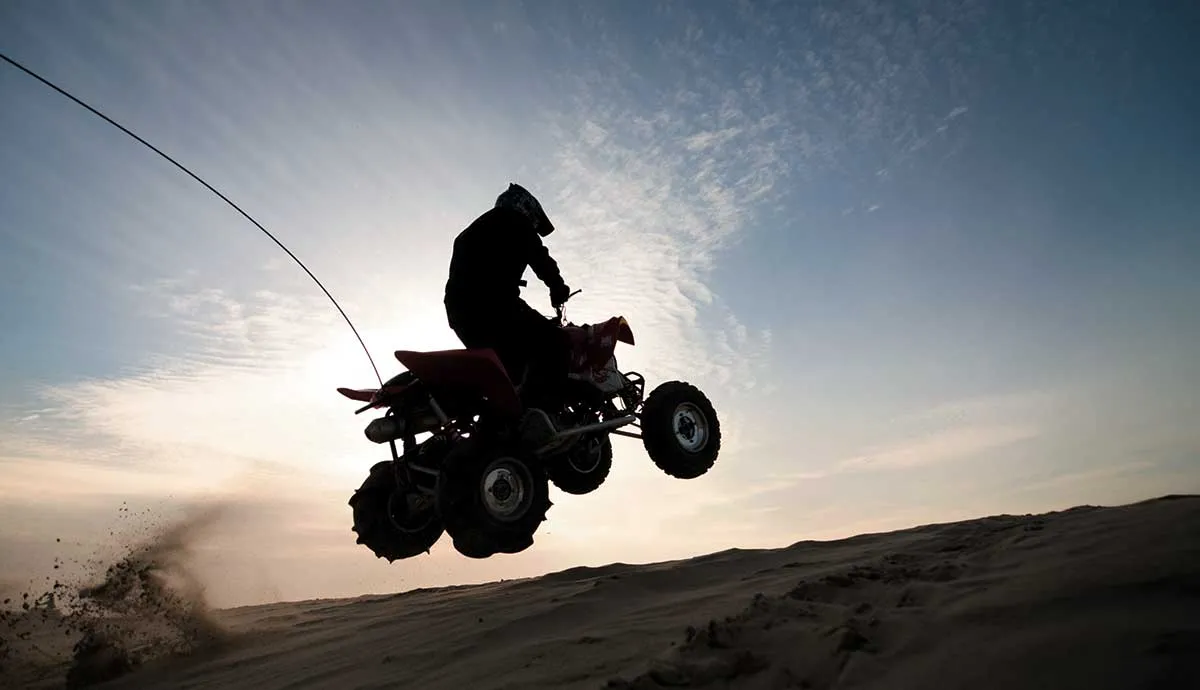 Silhouette of a person jumping quadbike